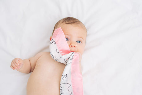 baby sleeping safely in cot with Bullabaloo satin edge muslin comforter